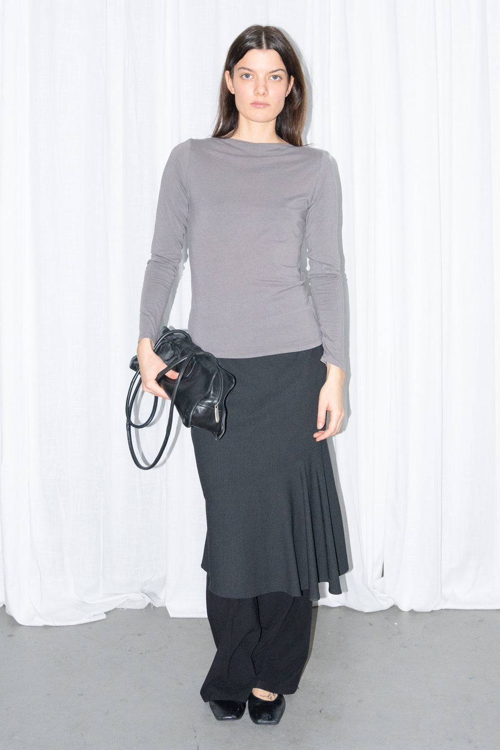 Model wearing grey fitted long-sleeve top with a black flared midi skirt – MINIFALDA