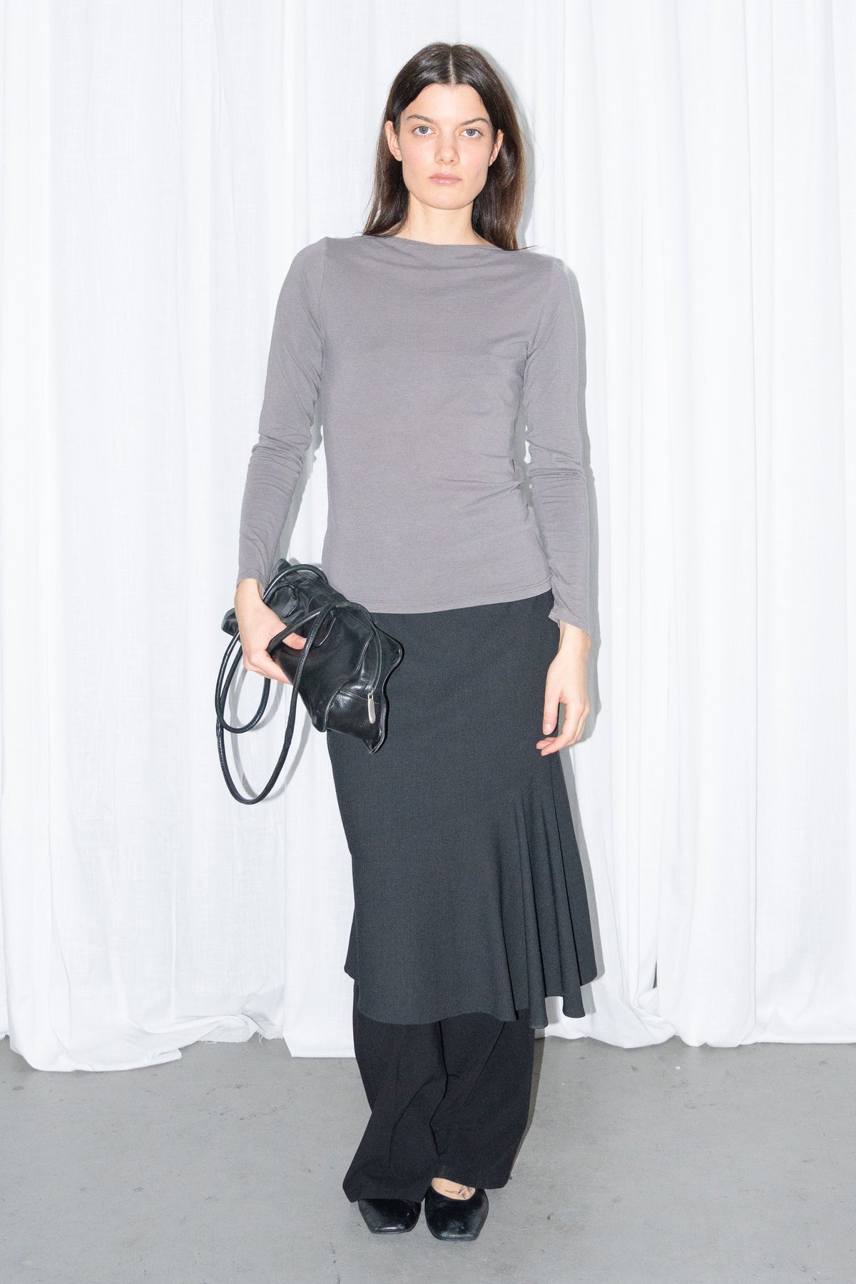 Model wearing grey fitted long-sleeve top with a black flared midi skirt – MINIFALDA