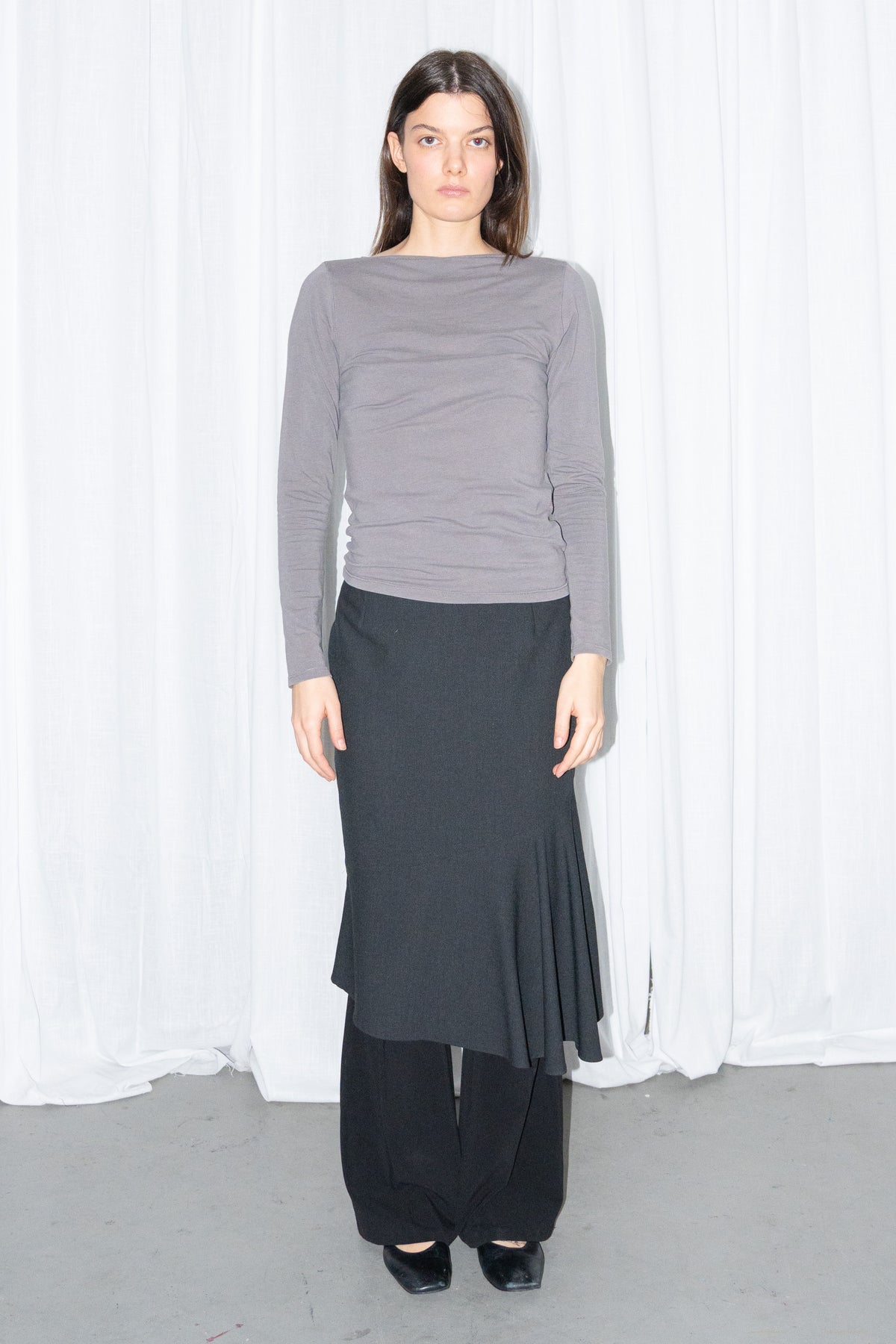 Model wearing grey fitted long-sleeve top with a black flared midi skirt – MINIFALDA