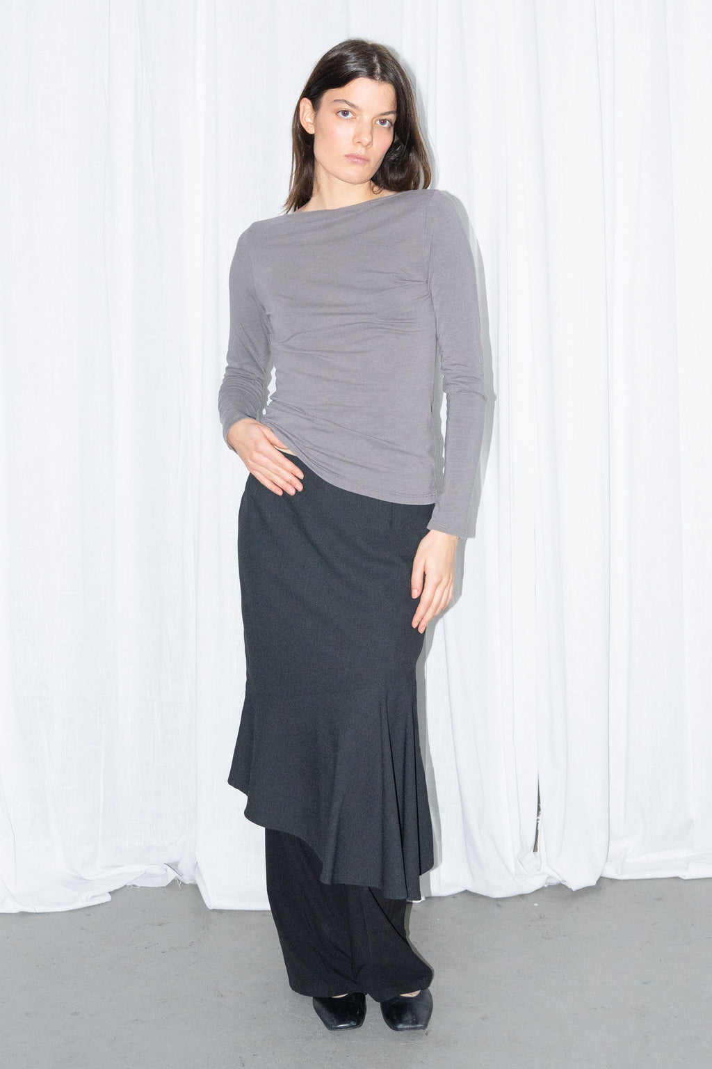 Model wearing grey fitted long-sleeve top with a black flared midi skirt – MINIFALDA