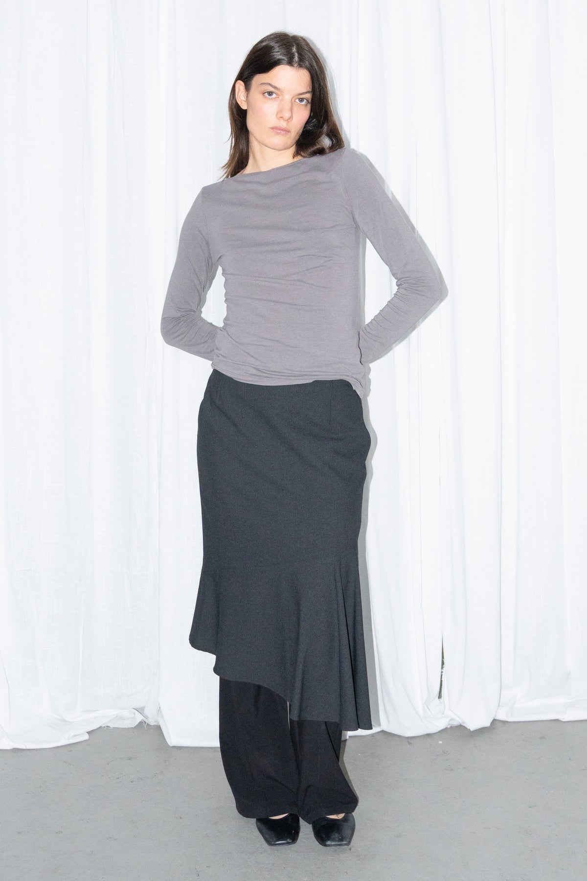 Model wearing grey fitted long-sleeve top with a black flared midi skirt – MINIFALDA