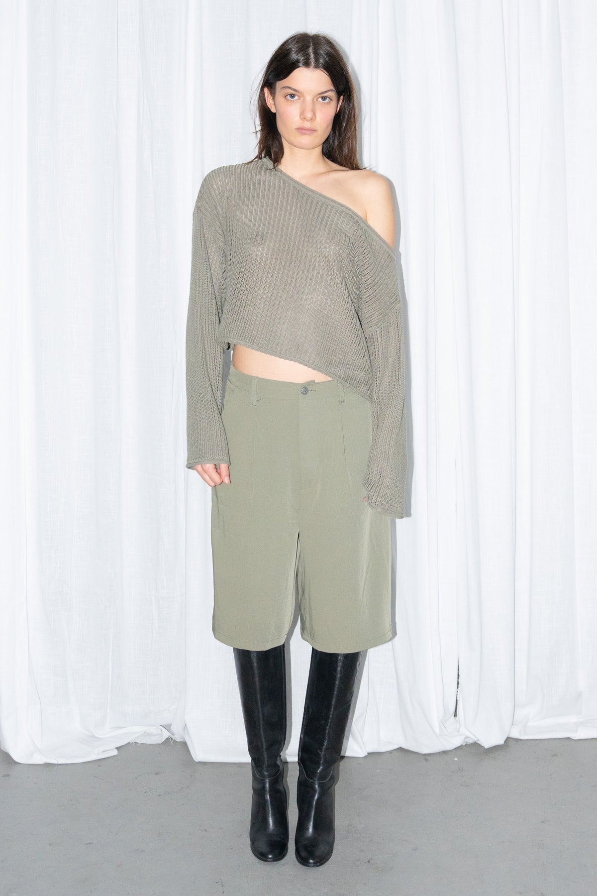 Front view of an olive off-shoulder knit sweater with khaki green Bermuda shorts