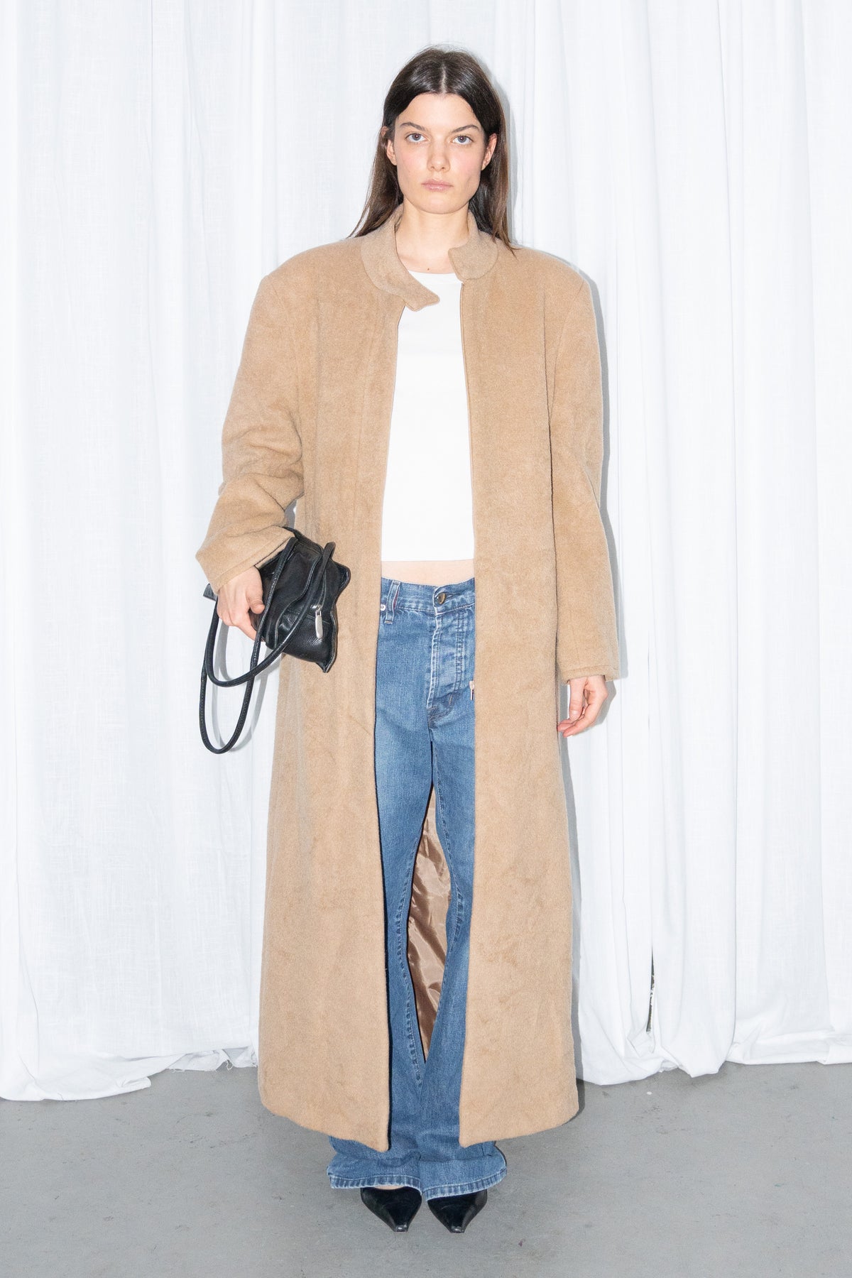 Model wearing camel long wool coat with a white top and jeans – MINIFALDA