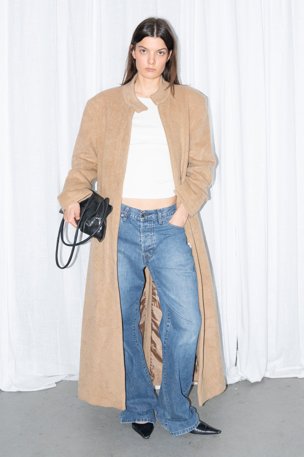 Model wearing camel long wool coat with a white top and jeans – MINIFALDA
