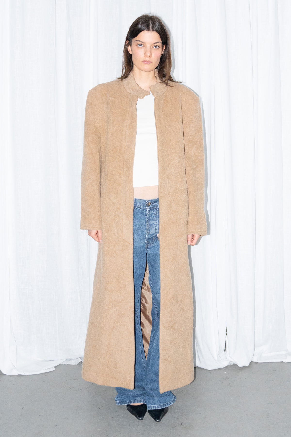 Model wearing camel long wool coat with a white top and jeans – MINIFALDA