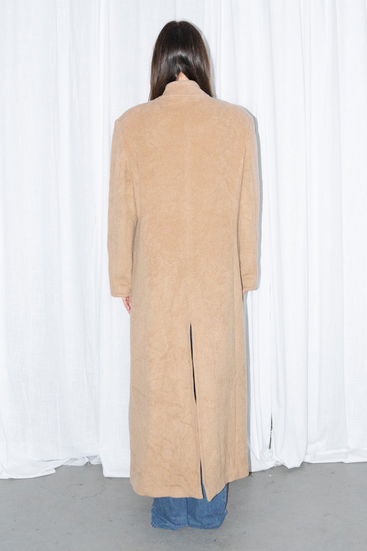 Model wearing camel long wool coat with a white top and jeans – MINIFALDA