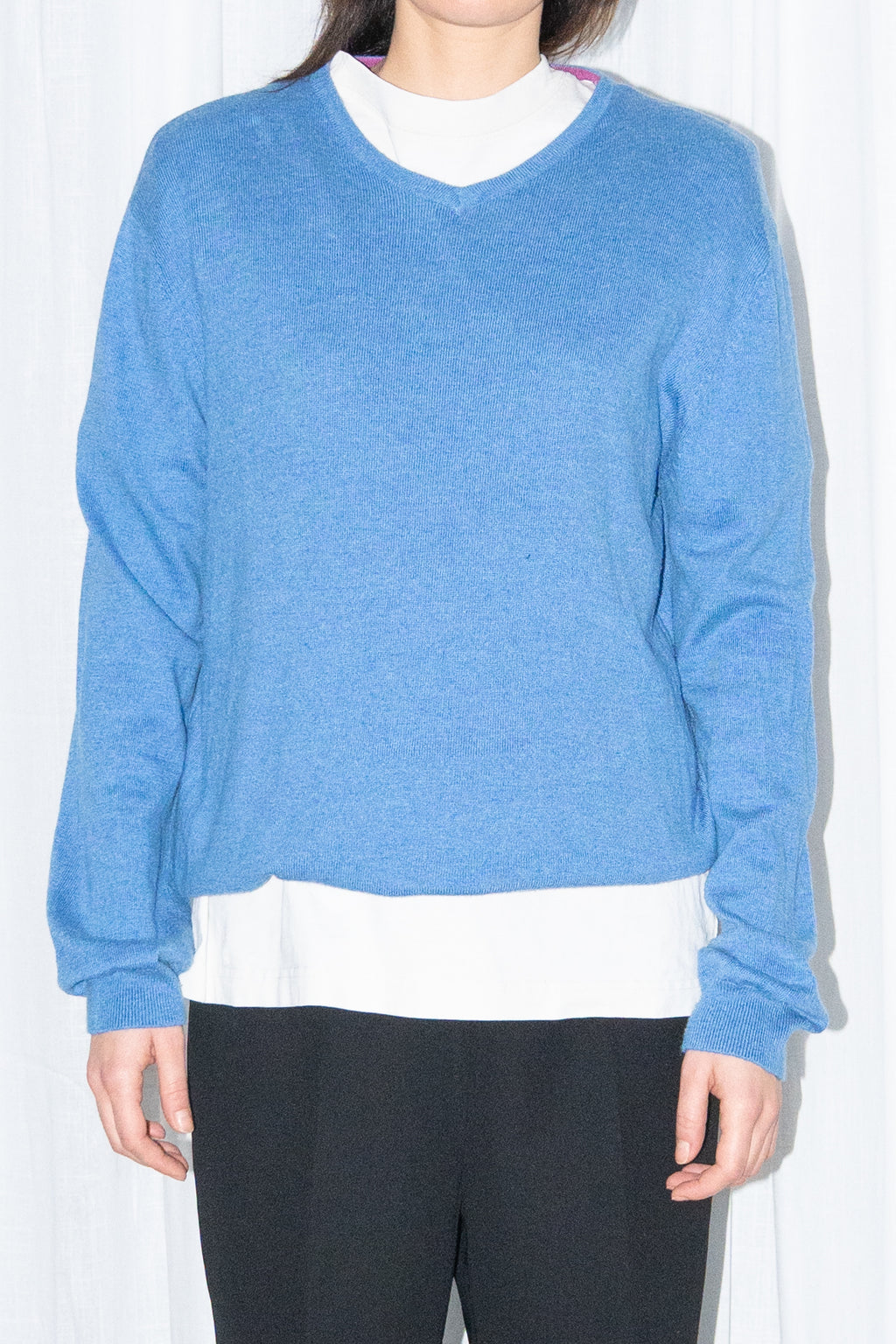 Close-up of blue V-neck knit sweater with black flared trousers – MINIFALDA