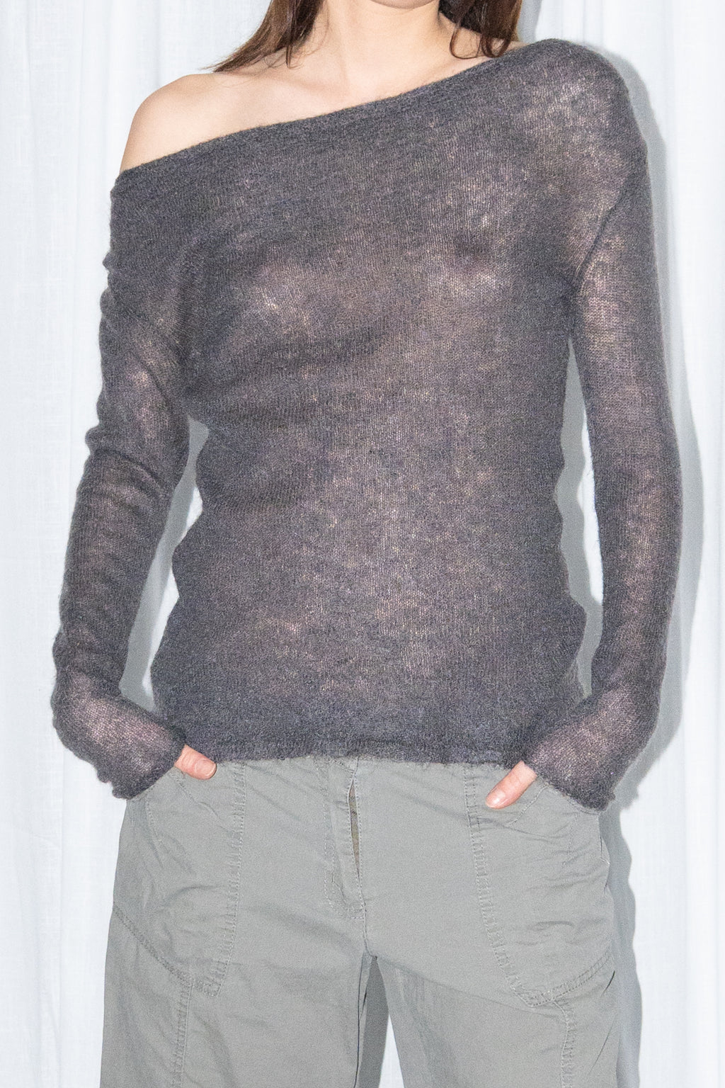 Close-up of a charcoal brown off-shoulder fitted top with khaki green cargo Bermuda shorts and black knee boots