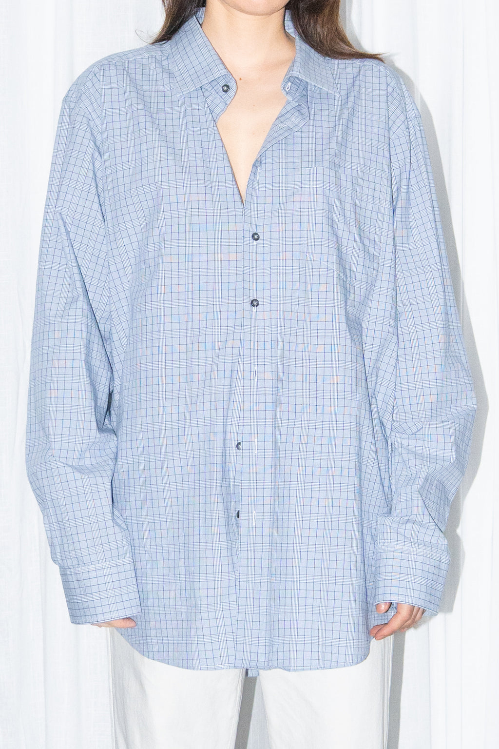 Close-up of a light blue oversized button-up shirt with white wide-leg trousers
