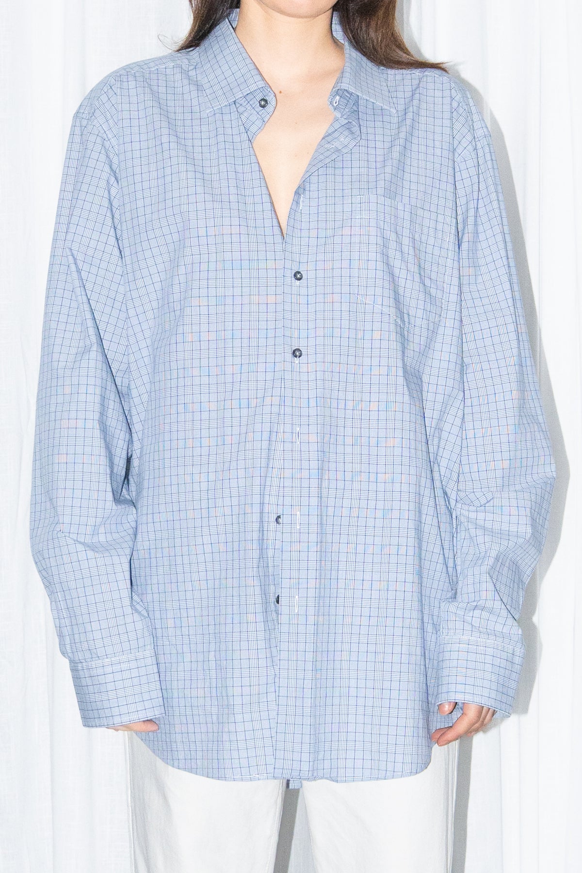Close-up of a light blue oversized button-up shirt with white wide-leg trousers