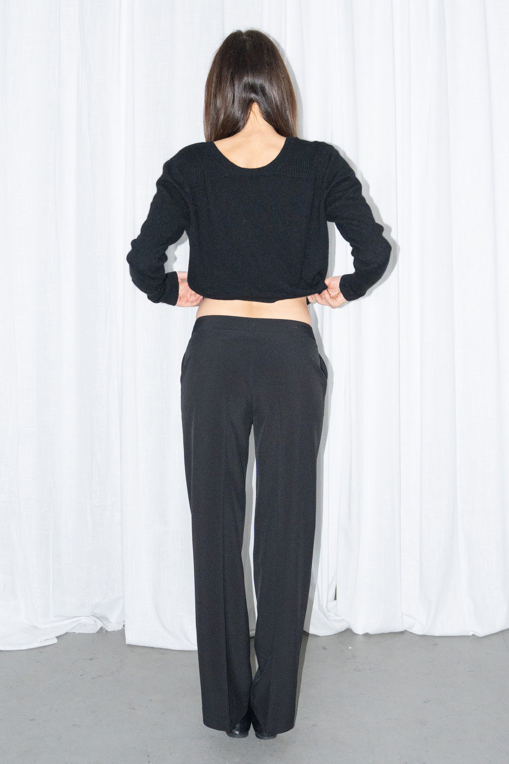 Front view of black tailored straight trousers with a black chunky knit cardigan