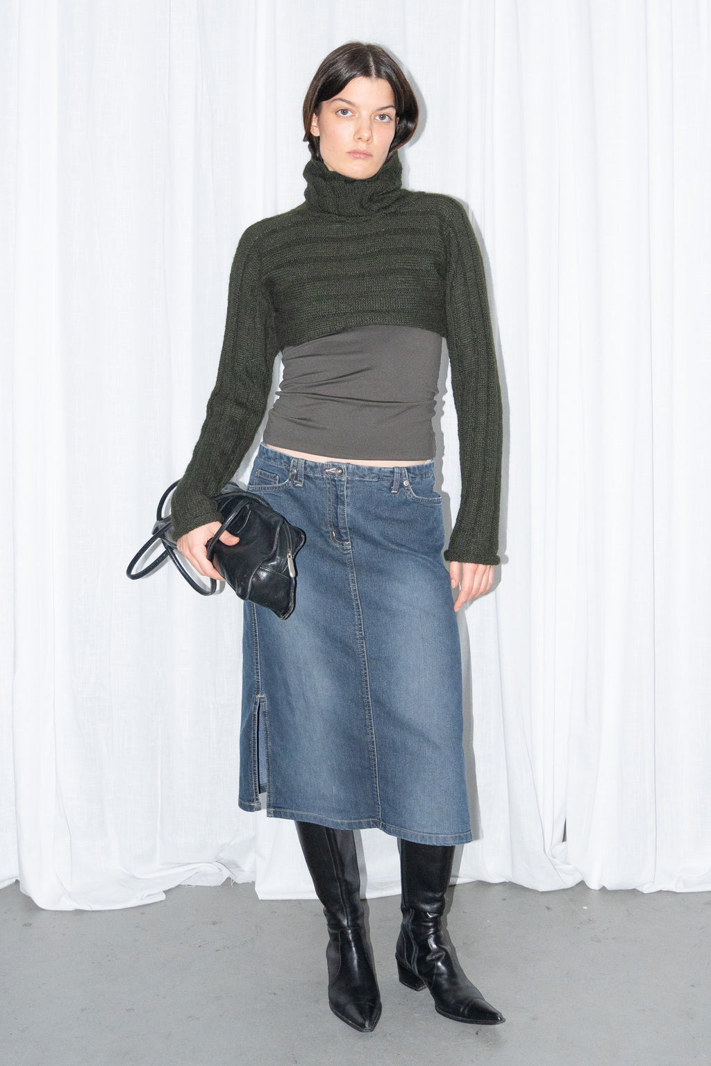 Model wearing dark green ribbed mohair and wool knit turtleneck bolero with a dark denim midi skirt – MINIFALDA
