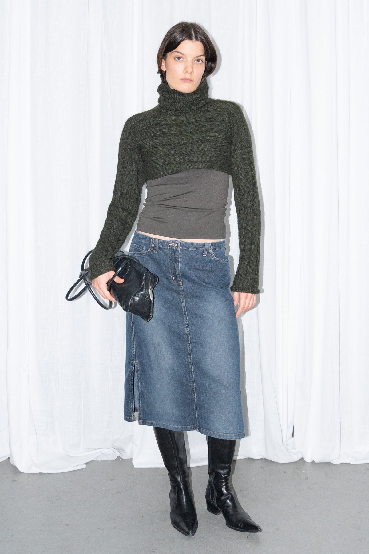 Model wearing dark green ribbed mohair and wool knit turtleneck bolero with a dark denim midi skirt – MINIFALDA