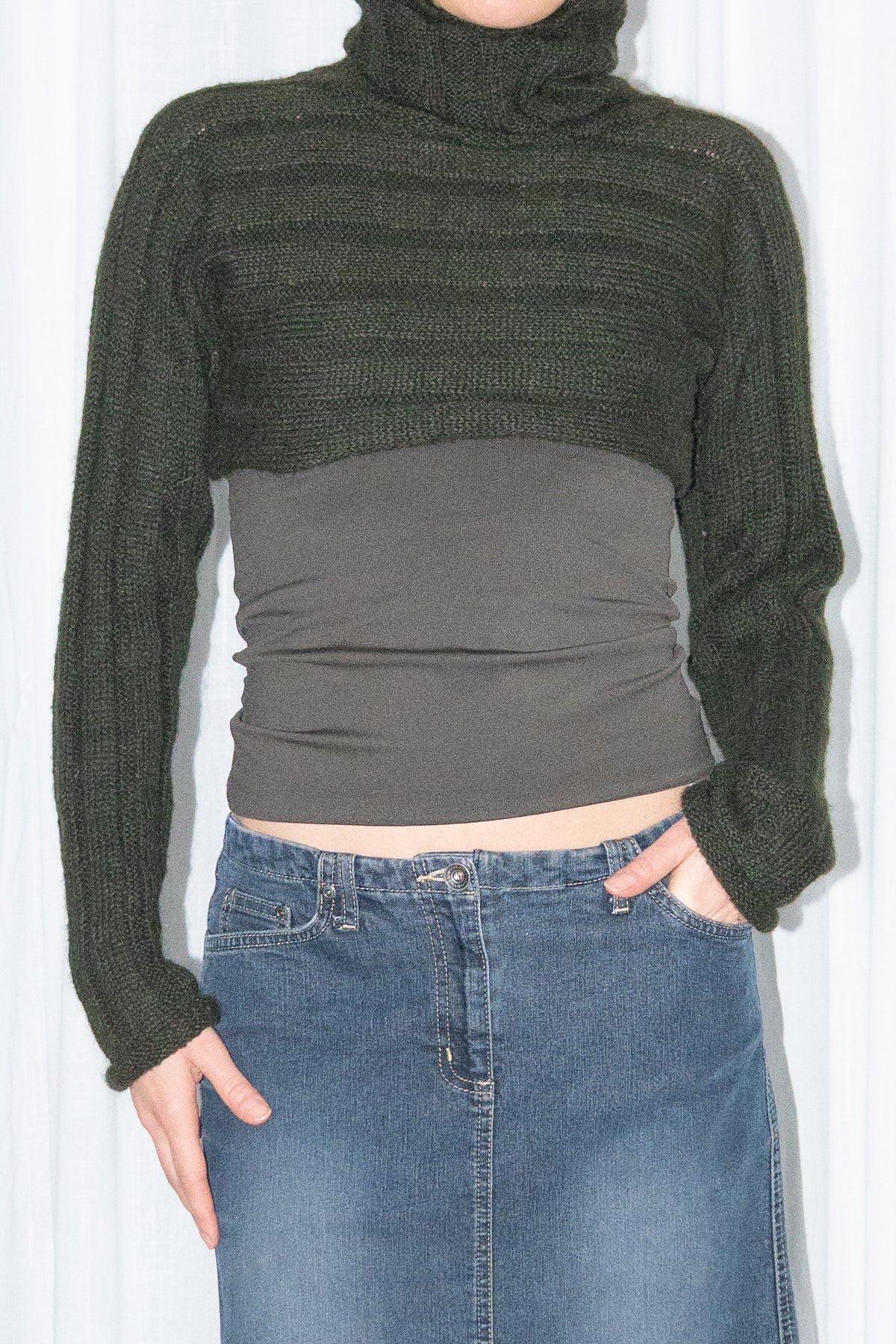 Close-up of dark green ribbed mohair and wool knit turtleneck bolero with a dark denim midi skirt – MINIFALDA