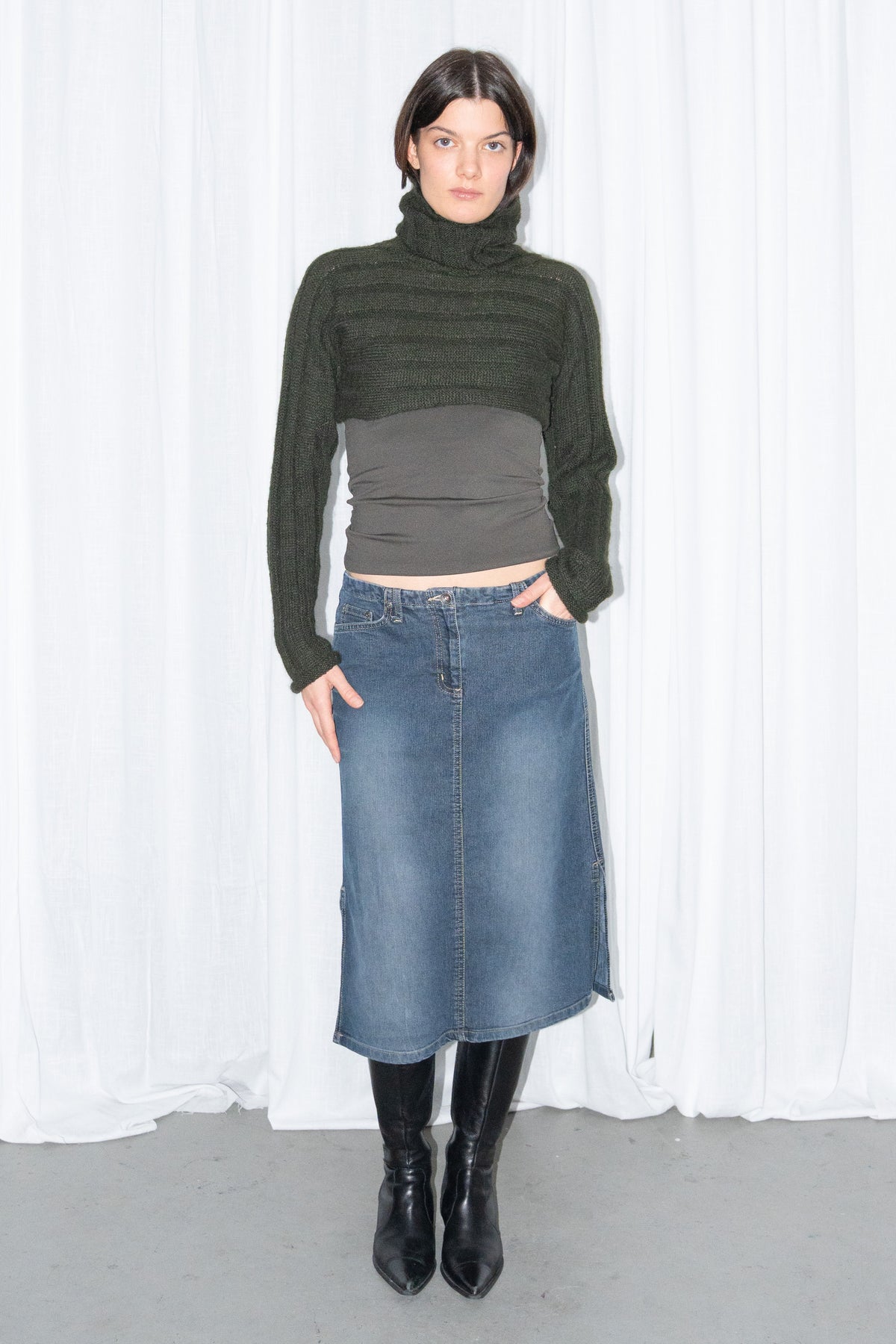 Model wearing dark green ribbed mohair and wool knit turtleneck bolero with a dark denim midi skirt – MINIFALDA
