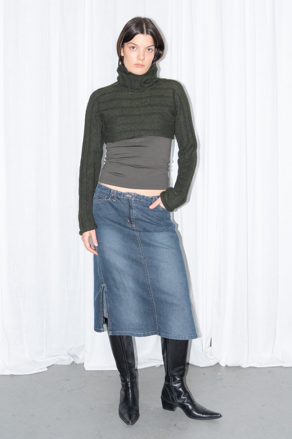 Model wearing dark green ribbed mohair and wool knit turtleneck bolero with a dark denim midi skirt – MINIFALDA