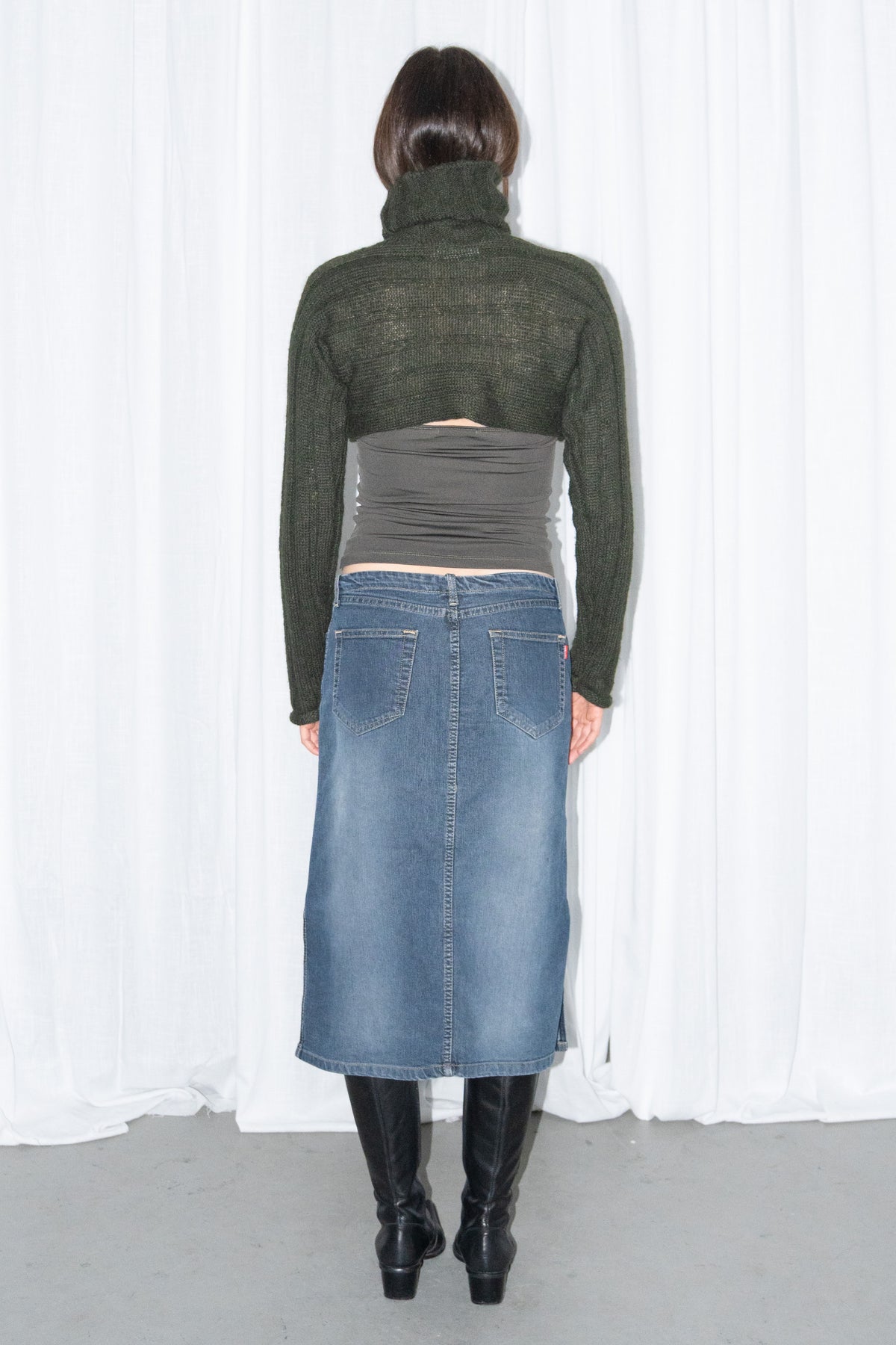 Model wearing dark green ribbed mohair and wool knit turtleneck bolero with a dark denim midi skirt – MINIFALDA